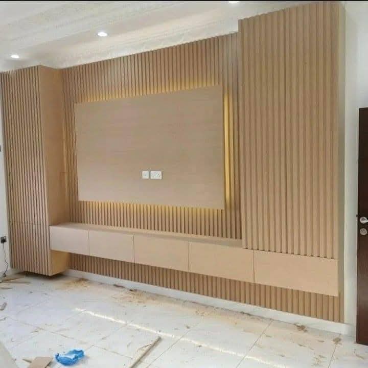 TV feature wall with built-in cabinetry and concealed lighting in a Doha living room (view 7)
